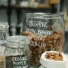 Glass jars and cloth bag filled with organic food, showcasing sustainable packaging in retail.