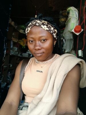Young woman with headband inside a store, posing confidently.