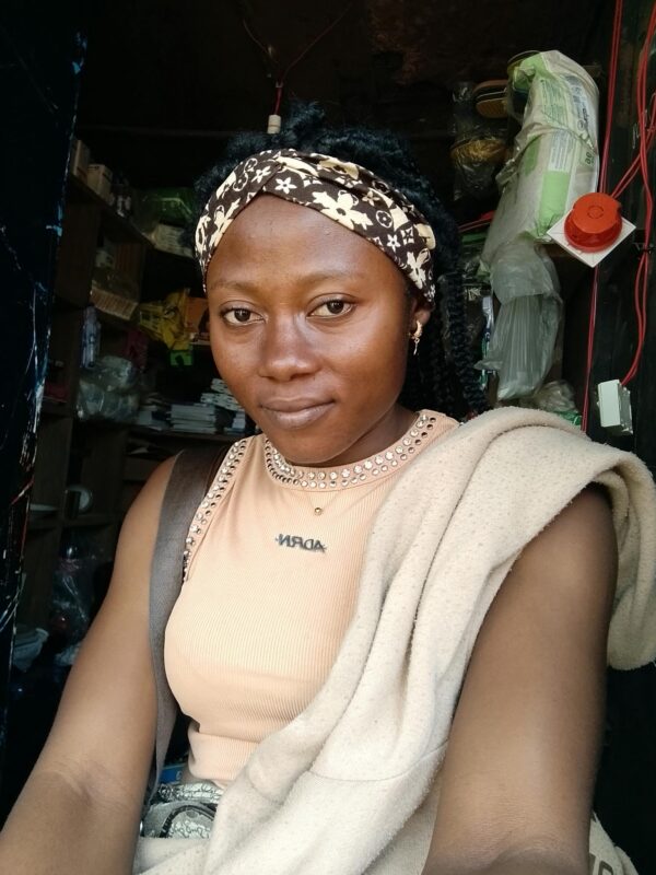 Young woman with headband inside a store, posing confidently.