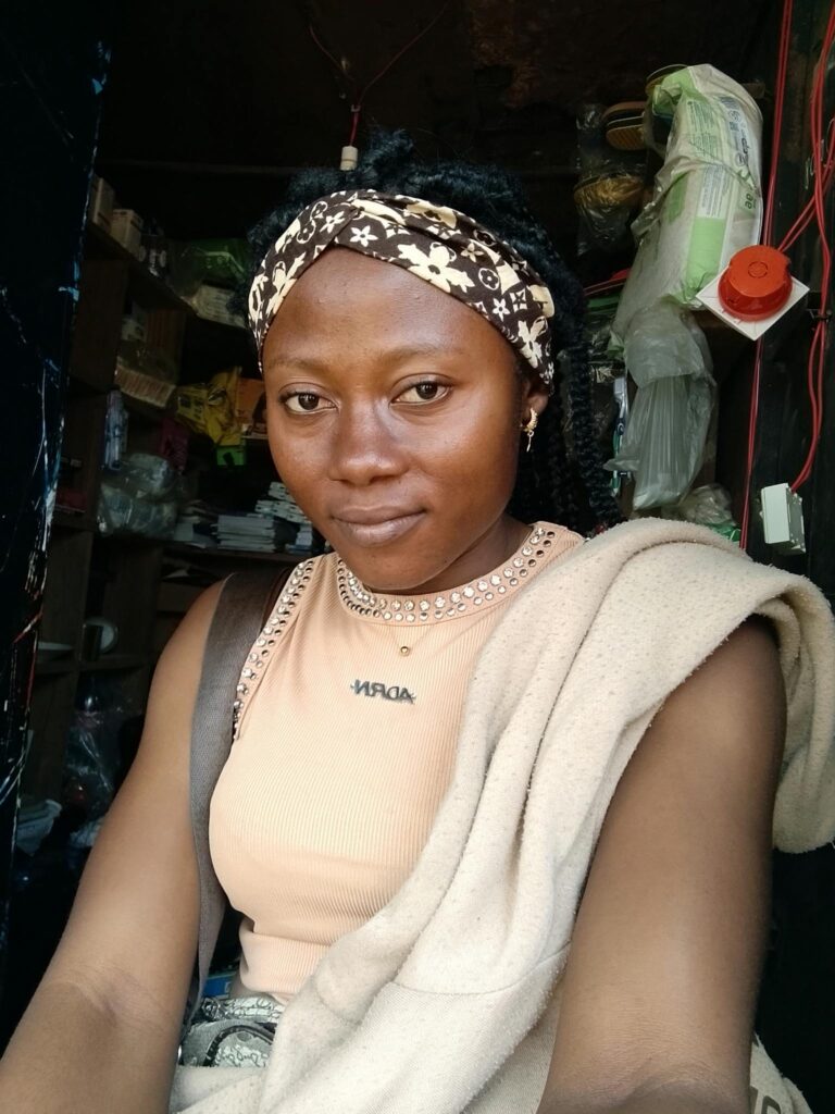 Young woman with headband inside a store, posing confidently.